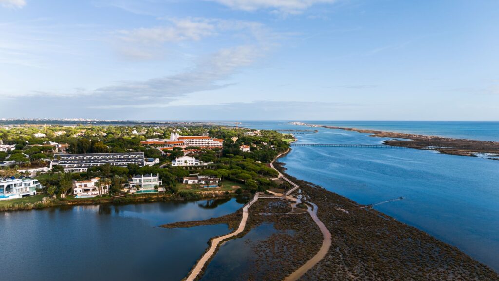 Quinta do Lago Wealth showcased in an aerial view of the Ria Formosa, Atlantic coastline, and the private estate setting in the Algarve.