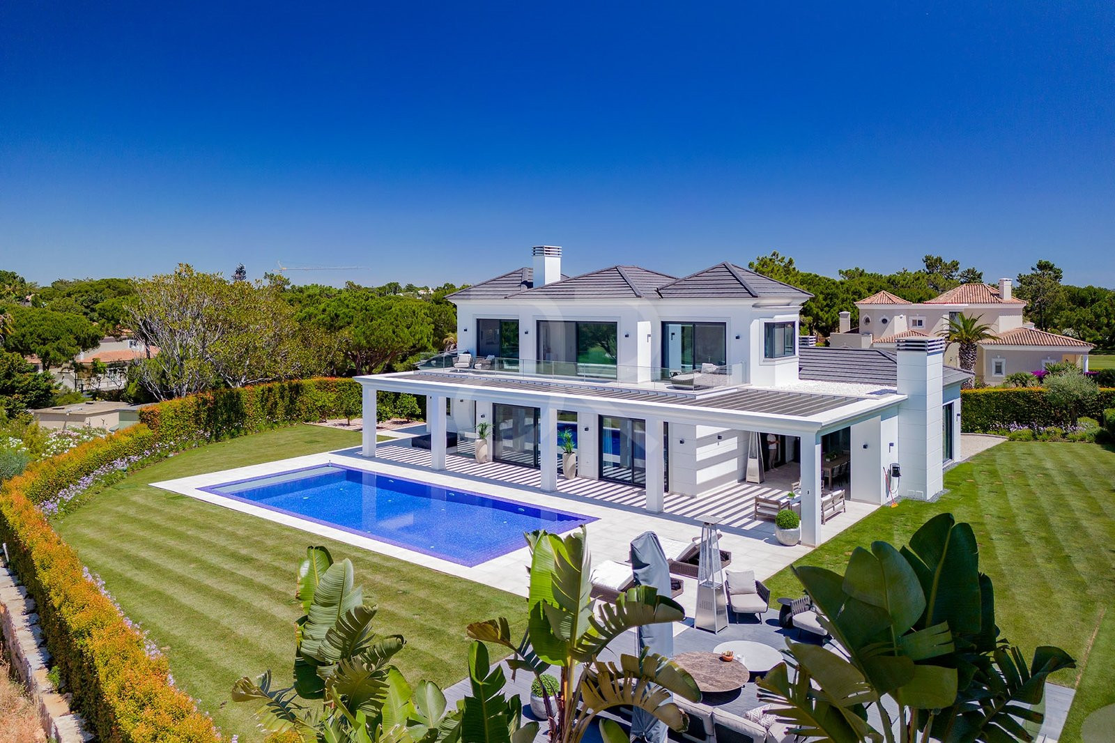 Luxury white villa with pool and manicured garden